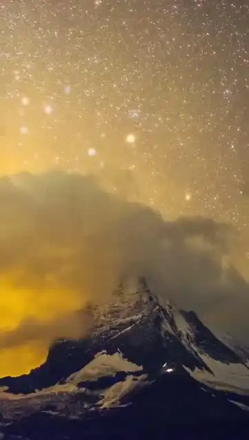 瑞士马特洪峰的星空与日出彩霞,峰脊上的灯光是勇敢的登山者们.