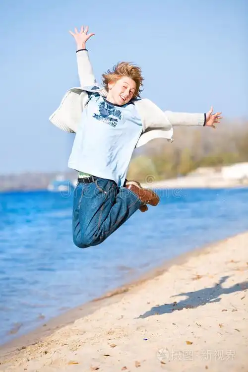 快乐的海滩跳跃男孩