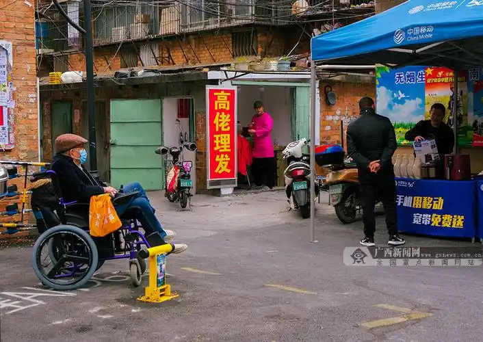 图为南宁市安达苑小区门口的一家理发店,老师傅正在给客人理发.