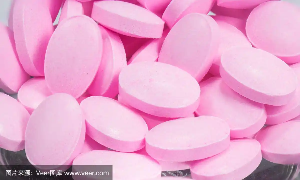 粉红色的药片在白色的背景上分离