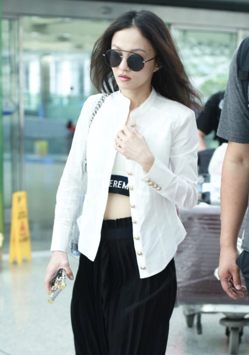 张韶涵现身北京机场 身穿黑白简约潮搭上衣解扣炫腹