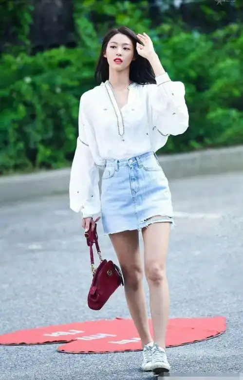 的设计更是为金雪炫增添了一抹妩媚,下身再搭配一件黑色不规则短裙,看