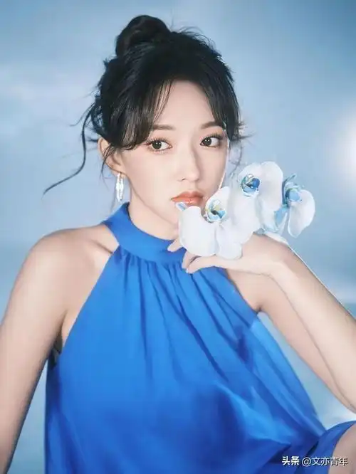 程潇,一袭露肩挂脖蓝色连衣裙,配上蓝心白蝴蝶兰,别有一番风味