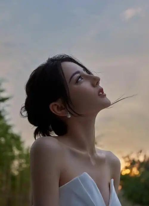 照片中迪丽热巴身穿一袭白裙,v领的设计将她那层次分明的锁骨以及直角