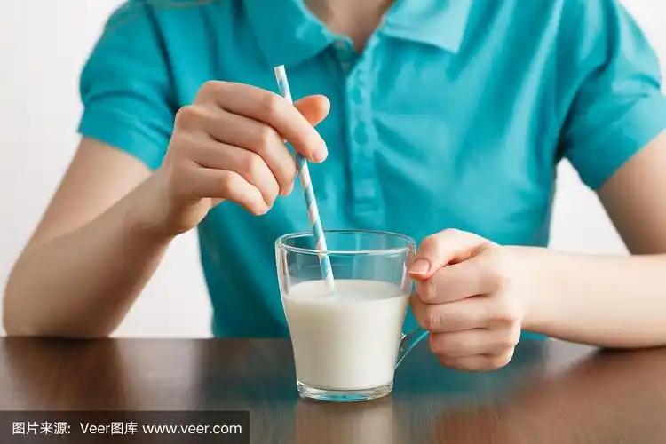 女孩以健康的生活方式喝牛奶,用吸管吃