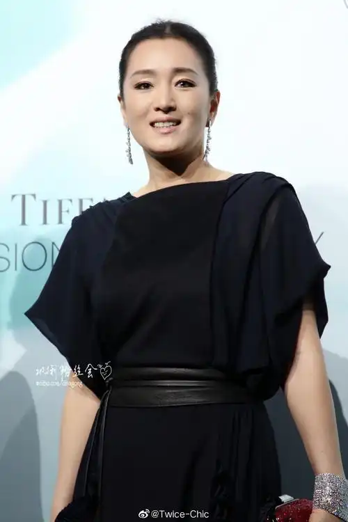 巩俐今日身着木耳边黑色礼服现身上海出席时尚活动