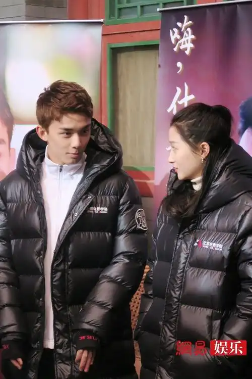吴磊,关晓彤两人身穿北京电影学院羽绒服,在《嗨,什刹海》片场认真