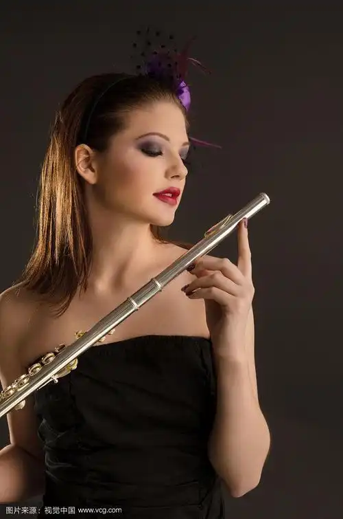 年轻的,漂亮的女孩拿着长笛,准备音乐会