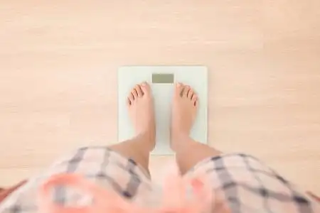 站在体重秤上的女人照片