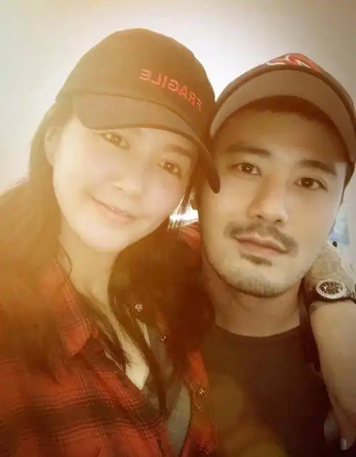 39岁谭维维疑似当妈与丈夫抱俩娃路边购物丈夫身材健硕皮肤黑