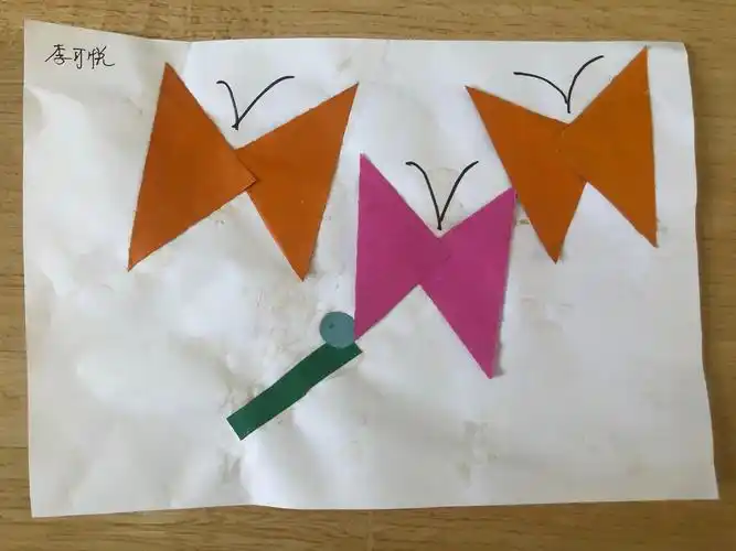 《蝴蝶》,通过认识图形来贴蝴蝶,培养幼儿的手工兴趣,增强幼儿对贴画