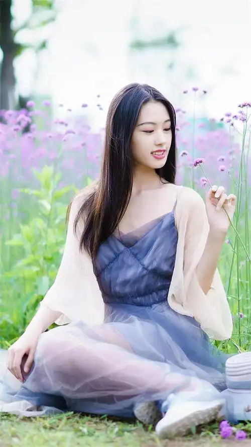 人像摄影紫花旁少女秀发飘飘笑容可掬