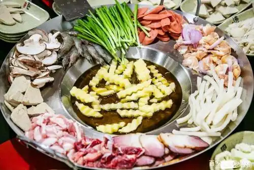 烙锅的锅四周平坦,中间凹陷,食材在中间炸熟后放到四周供人挑夹.