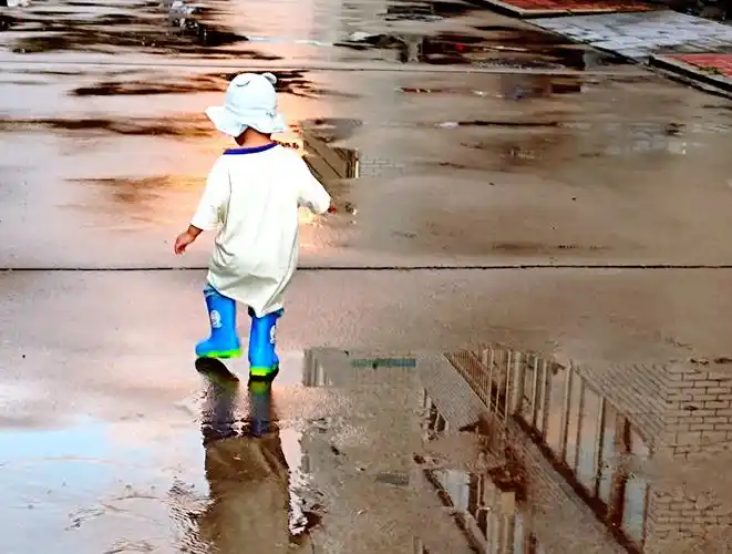 雨后踩水玩的孩子