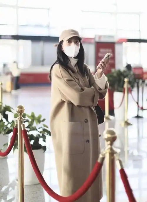 高圆圆现身机场,翻领羊绒大衣搭长筒靴,时尚优雅又显气质