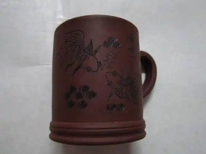 一把紫砂杯(底部有"宜兴紫砂珍藏品蒋祥君制陶"字样)