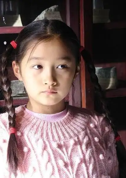 关晓彤还有着现在很流行的一字眉,头上戴着发箍,没想到小时候的她就