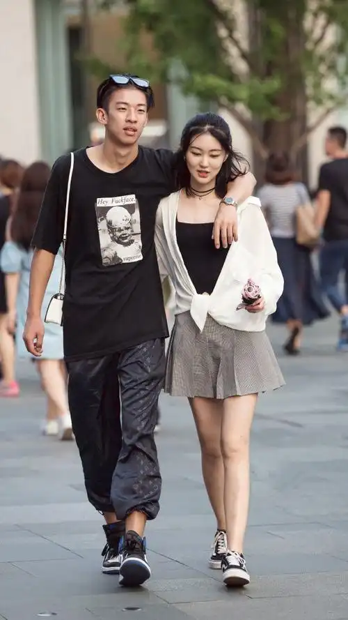 街拍:美女身穿黑色长裙,上面搭配白色的衣服,好看又个性!