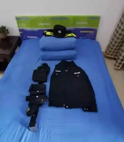 一张床上整齐叠放着一套警服,警帽以及出警装备,这是英雄杨志伟生前最