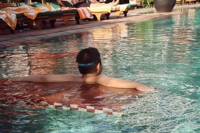 男孩在游泳池中游泳