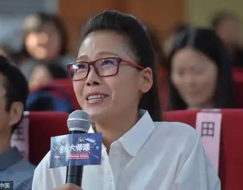 田震面戴框架眼镜身穿白衬衫为学生上课.