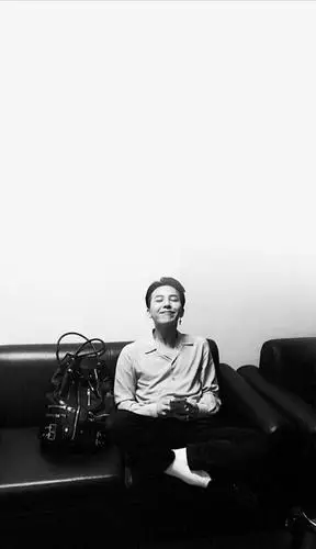 旁边有一个大包,权志龙手里拿着手机仰头笑的黑白照片,要全屏的