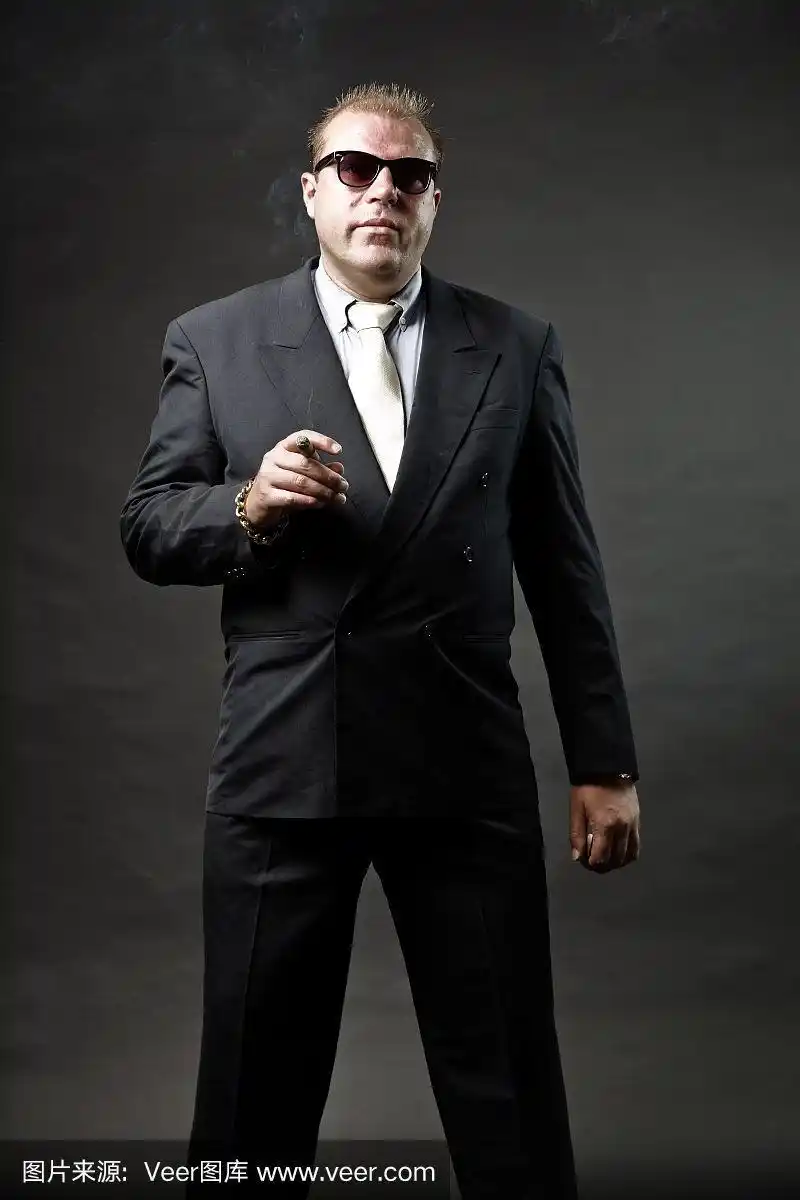 穿着西装,戴着墨镜,抽着雪茄的黑帮成员.