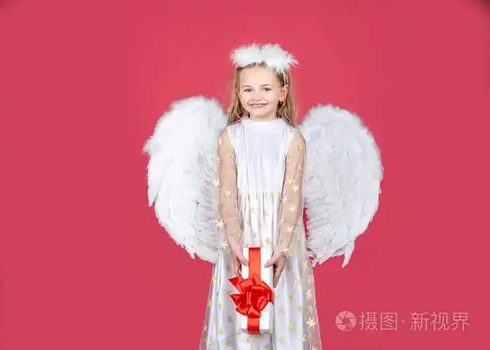 小天使女孩穿着白色裙子,在孤立的背景上有天使的翅膀.