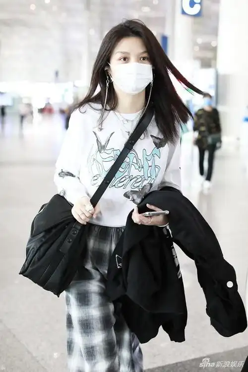 春夏赶飞机口罩遮素颜2021年6月1日,北京,演员春夏亮相机场,她身穿