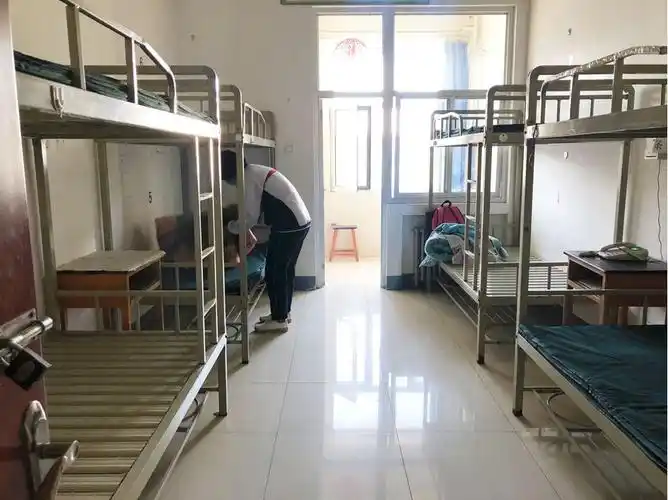 宿舍前有专门人员对行李进行消毒,志愿者帮忙把行李送进宿舍.