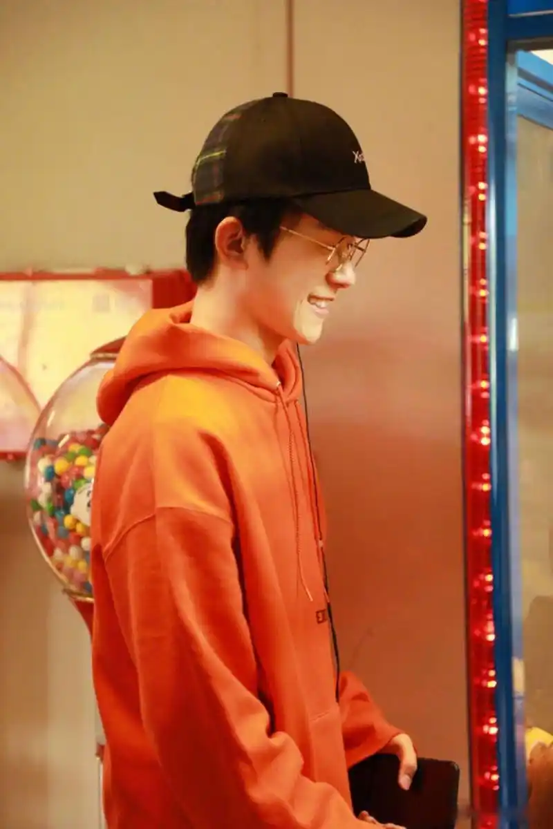 易烊千玺抓娃娃~橙色卫衣配黑色鸭舌帽,休闲舒适装扮,这一身少年气