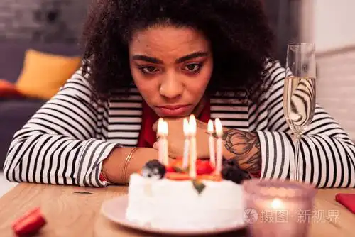 忧郁的生日独自庆祝生日时看着蜡烛的不快乐的女人