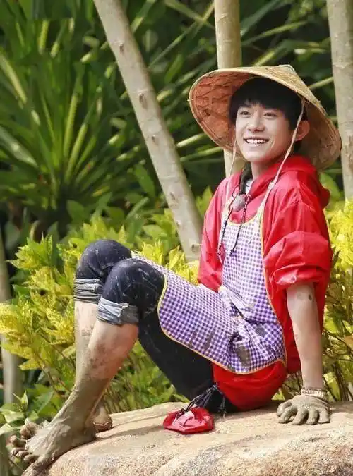 从照片中可以看到易烊千玺还是一如既往穿着红色连帽卫衣,不过这次是