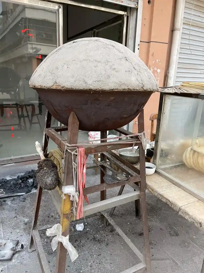 集市上还能看到这种年代感的烧饼炉确实不多了,两口铁锅相对扣在一起