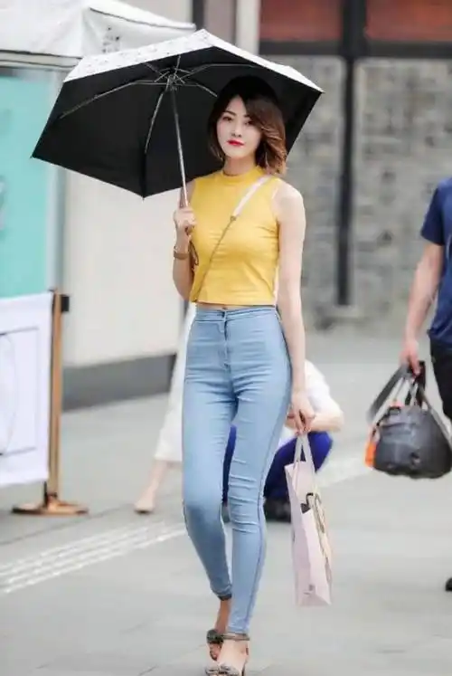 路人街拍浅蓝色牛仔裤搭配挂脖式背心看起来美美的