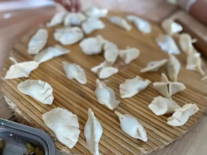 有的现学现试,认真投入;有的嬉闹可爱,别出心裁,包出的饺子形状各异