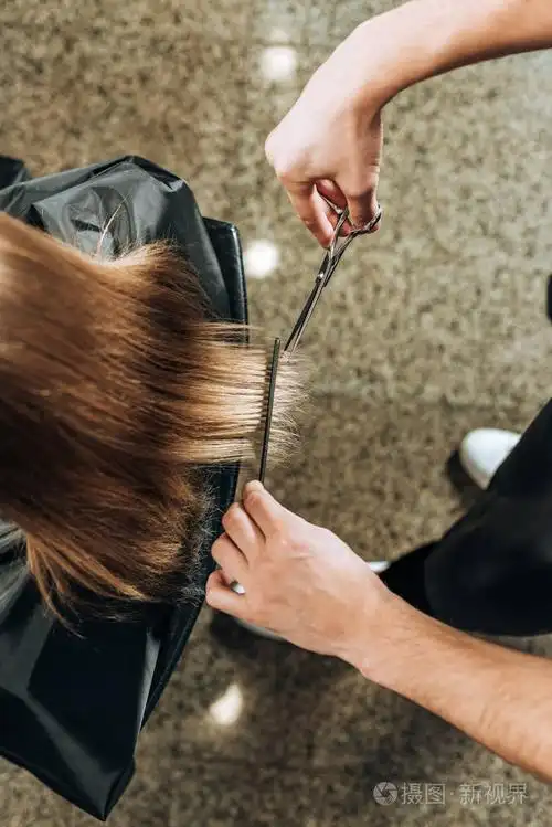 理发师剪发给美容院年轻妇女剪发的局部俯视图
