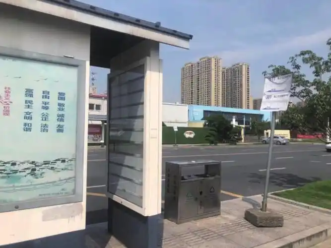 路社区服务中心公交站台,崭新的候车亭旁却依旧竖立着临时铁杆站牌