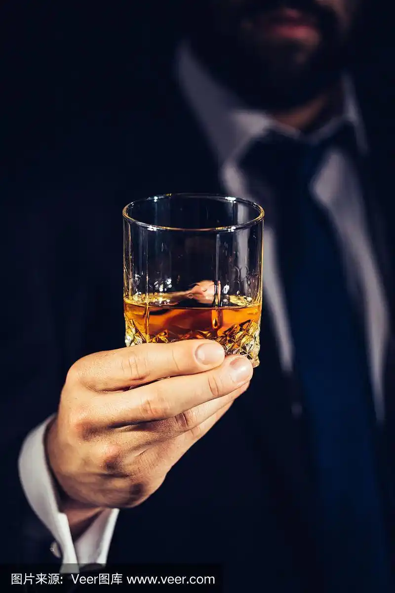穿着西装拿着一杯酒的男人