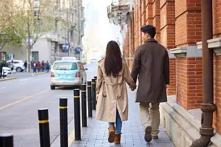 甜蜜情侣冬季户外牵手逛街背影图片素材