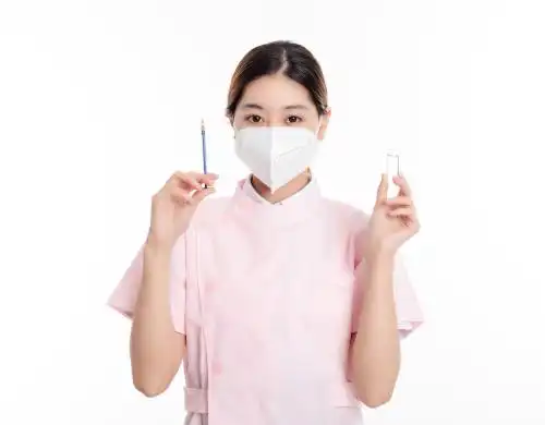 白色背景中的中国年轻女护士在使用注射器