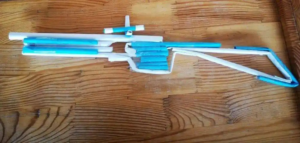 妈妈负责用搜索手枪的图片,爸爸负责把奶箱纸壳剪成条,然后粘成枪管和