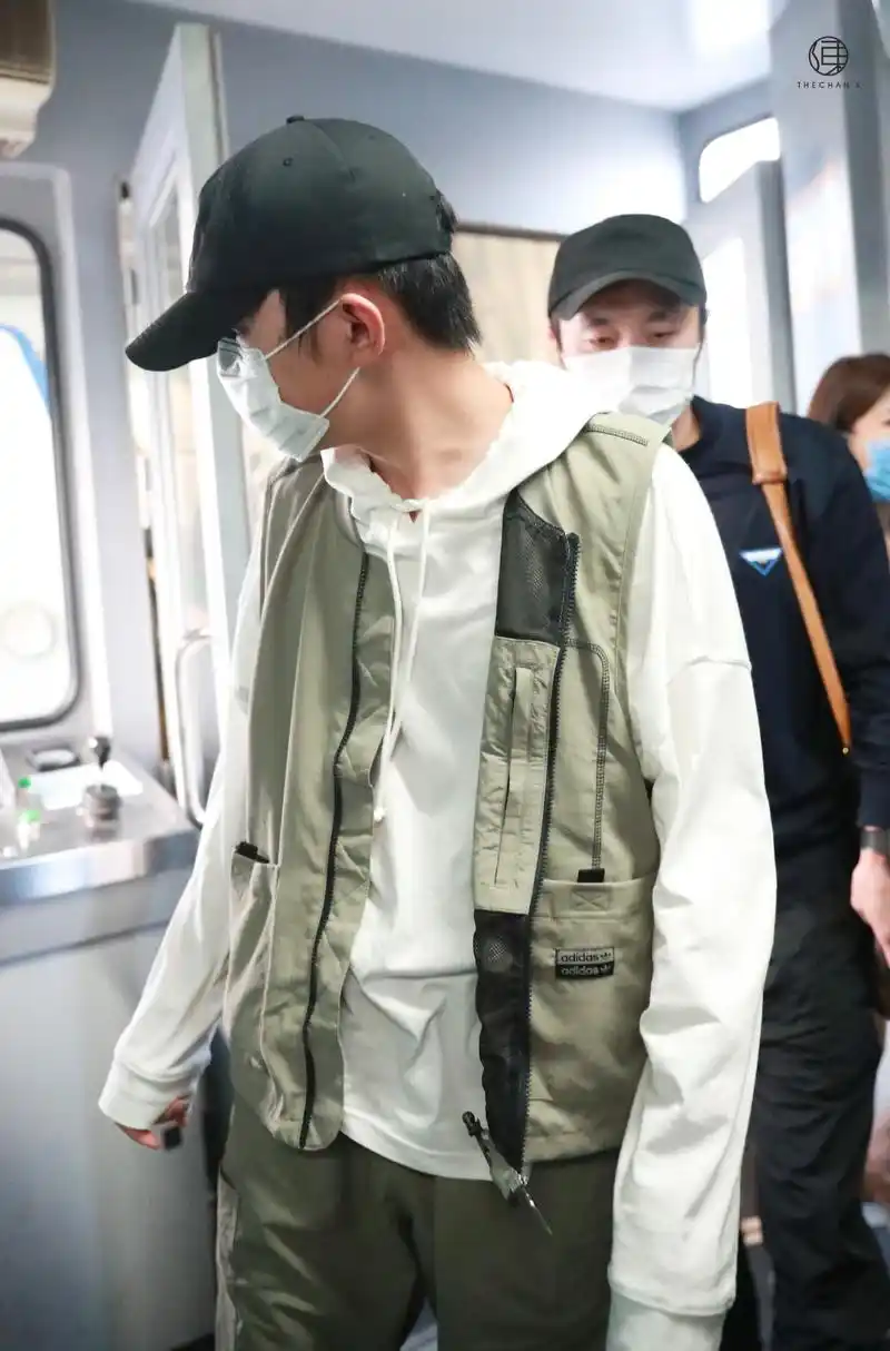 易烊千玺机场饭拍,白色连帽卫衣外搭工装马甲,低调又帅气的少年