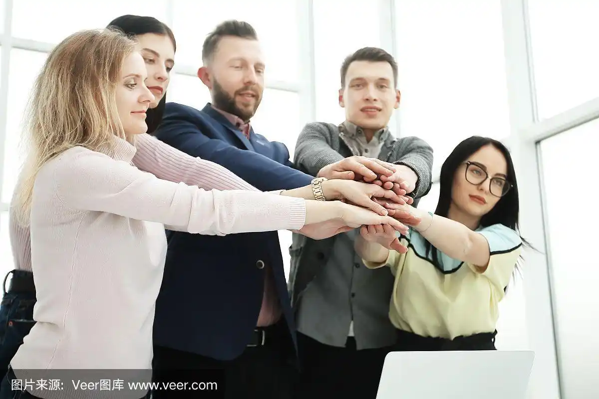 年轻的员工在桌子上双手合十.