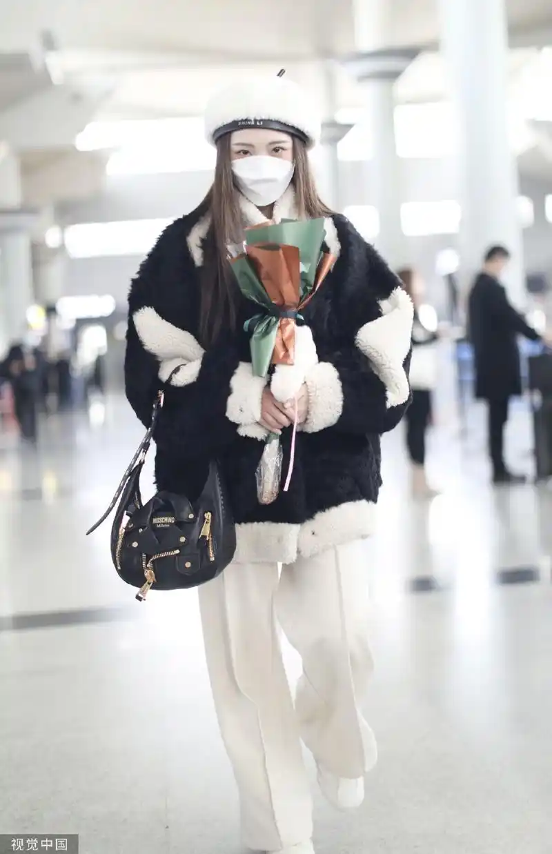 组图:郑乃馨戴白色贝雷帽现身机场 手捧粉丝赠送花束笑眼弯弯