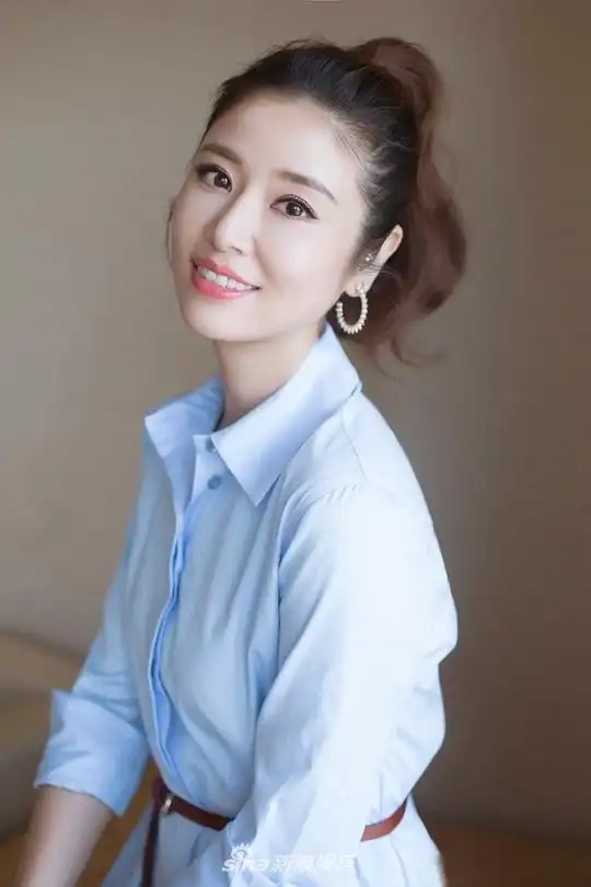 林心如最新写真,头扎高马尾,身穿粉蓝色衬衫式连衣裙,搭配腰间的牛皮