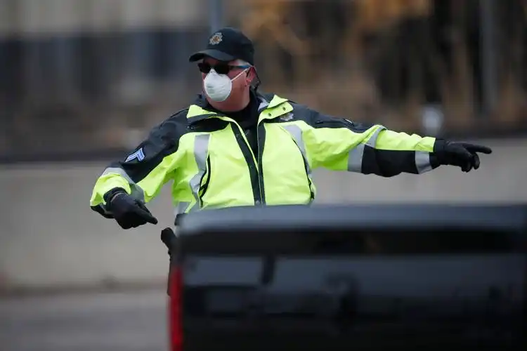 department officer wears a surgical mask while directing traffic