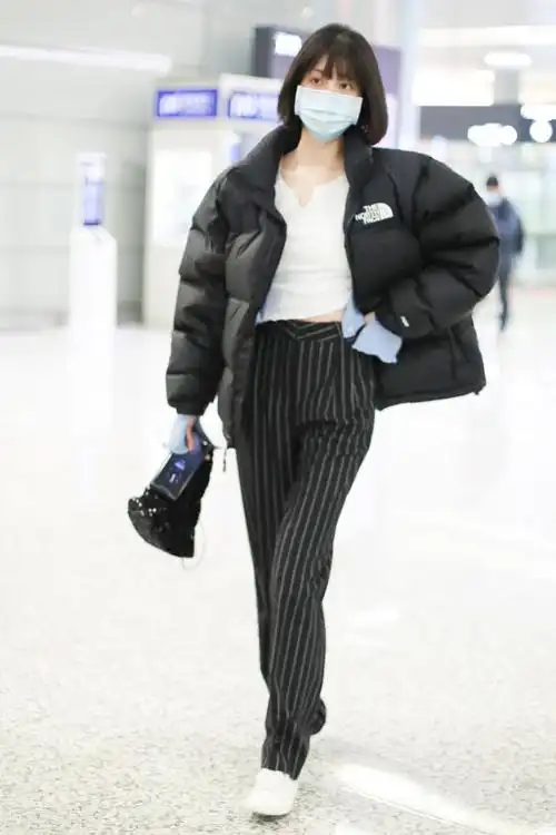 李溪芮黑白穿搭现身机场搭配黑色条纹裤尽显好身材