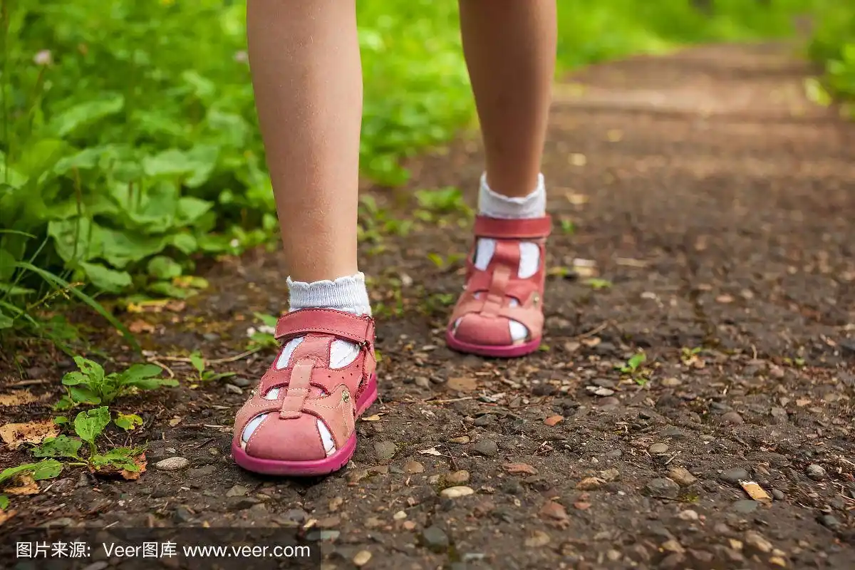 小女孩脚穿凉鞋走在石林小路上