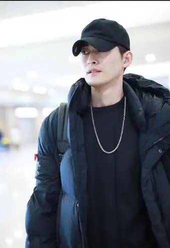 张翰身穿黑色长款羽绒服内搭黑色卫衣现身机场颜值在线精致帅气